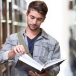 a boy reading book in the library