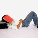 high school senior with notebook over her head