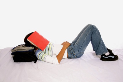 high school senior with notebook over her head