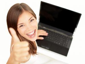 student smiling holding laptop