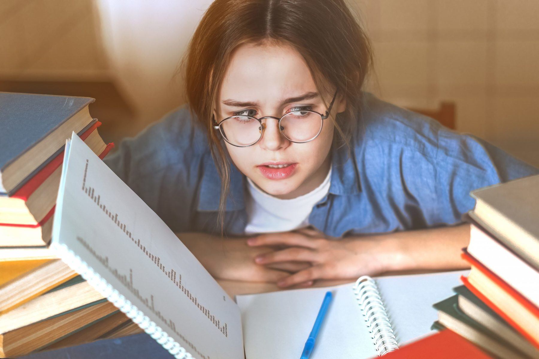 Stressed college student tired of hard learning with books in exams tests preparation, overwhelmed high school teen girl exhausted with difficult studies or too much homework, cram concept