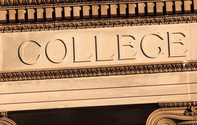Stone building facade with the word COLLEGE engraved in large capital letters above an ornate decorative border.
