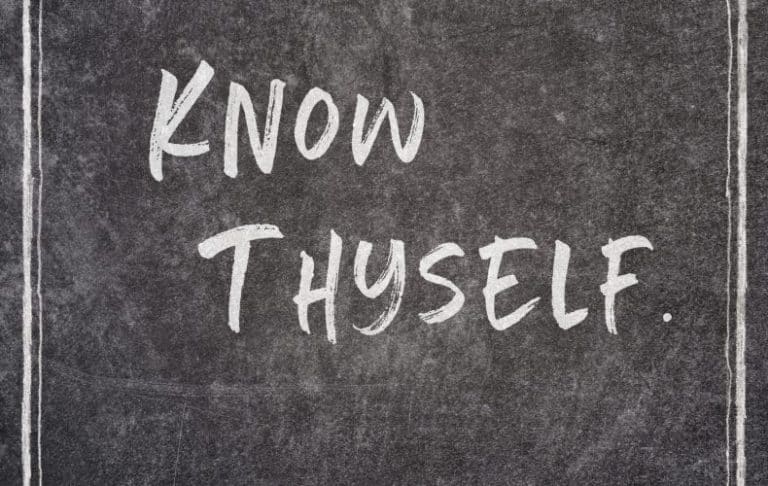 The phrase Know Thyself. is written in bold, white, handwritten-style letters on a dark chalkboard background with thin vertical white lines framing the sides.