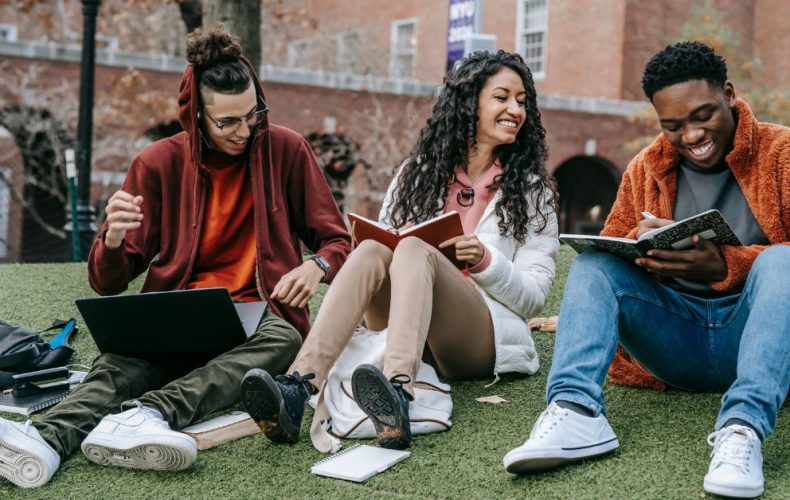 students sitting and holding books in hand