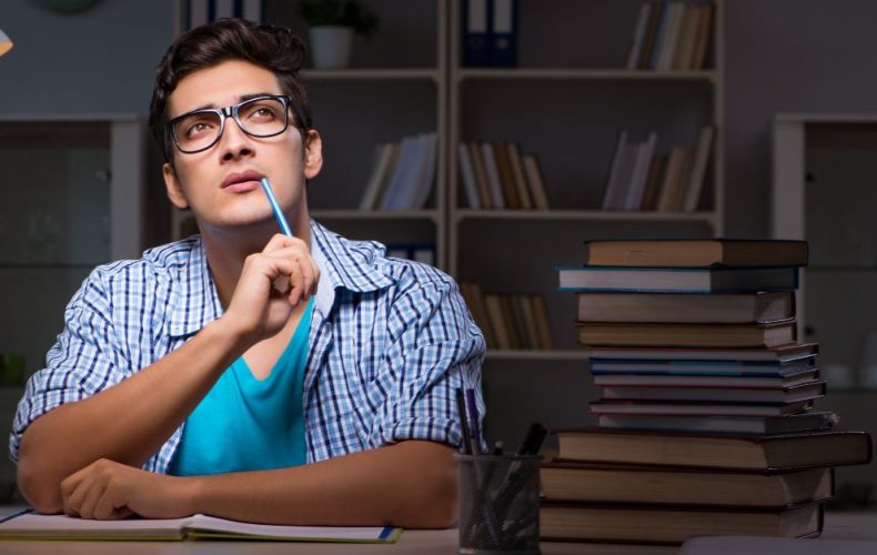 a boy in blue shirt thinking about writing the first line of the essay