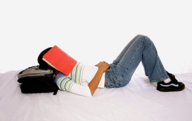 high school senior with notebook over her head